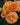 Close-up of peach-orange roses with layered petals and small buds, set against a blurred green garden background.