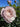 A close-up of a pale pink rose bloom with green leaves and buds against a bright blue sky.