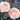 Two peachy pink old fashioned roses with green leaves and purple flowers in the background