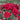 A close-up view of a cluster of deep red roses in full bloom with green leaves, set against a blurred background of more flowers and trees under a blue sky.