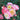 Cluster of yellow and pink roses surrounded by small rose buds and green leaves. 